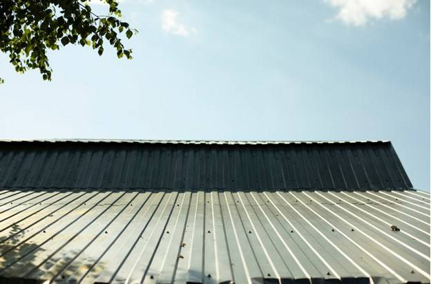 Монтаж листов профнастила на односкатной крыше завершает строительство